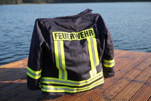ENT Einsatzjacke Symbolfoto mit einer Einsatzjacke auf einem Stuhl hängend der auf einem Steg am See steht