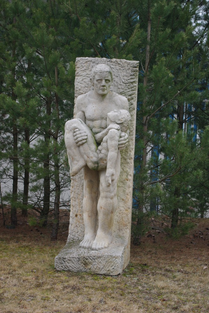 ENT Skulptur Symbolfoto einer Skulptur eines Menschen der einen hilflosen Menschen in seinen Armen trägt